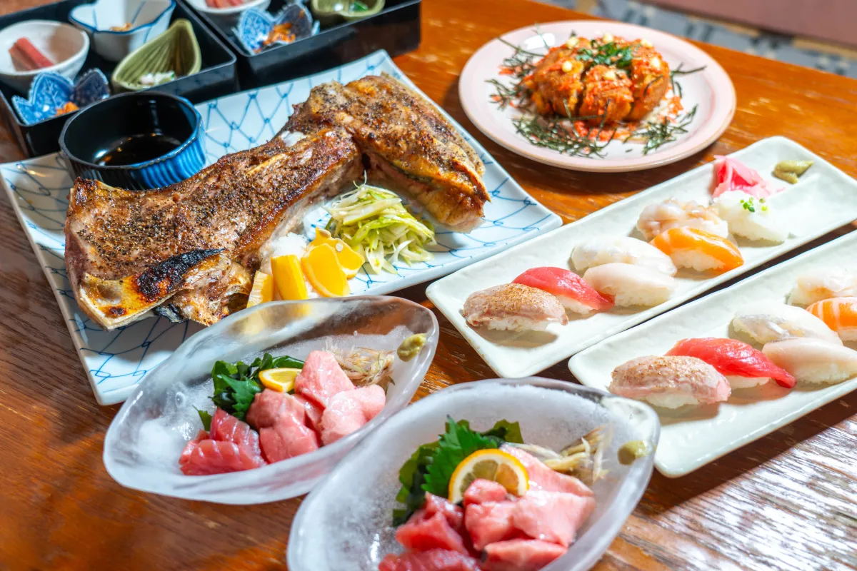 マグロの刺身とカマ焼き、日本酒を並べた料理のイメージ